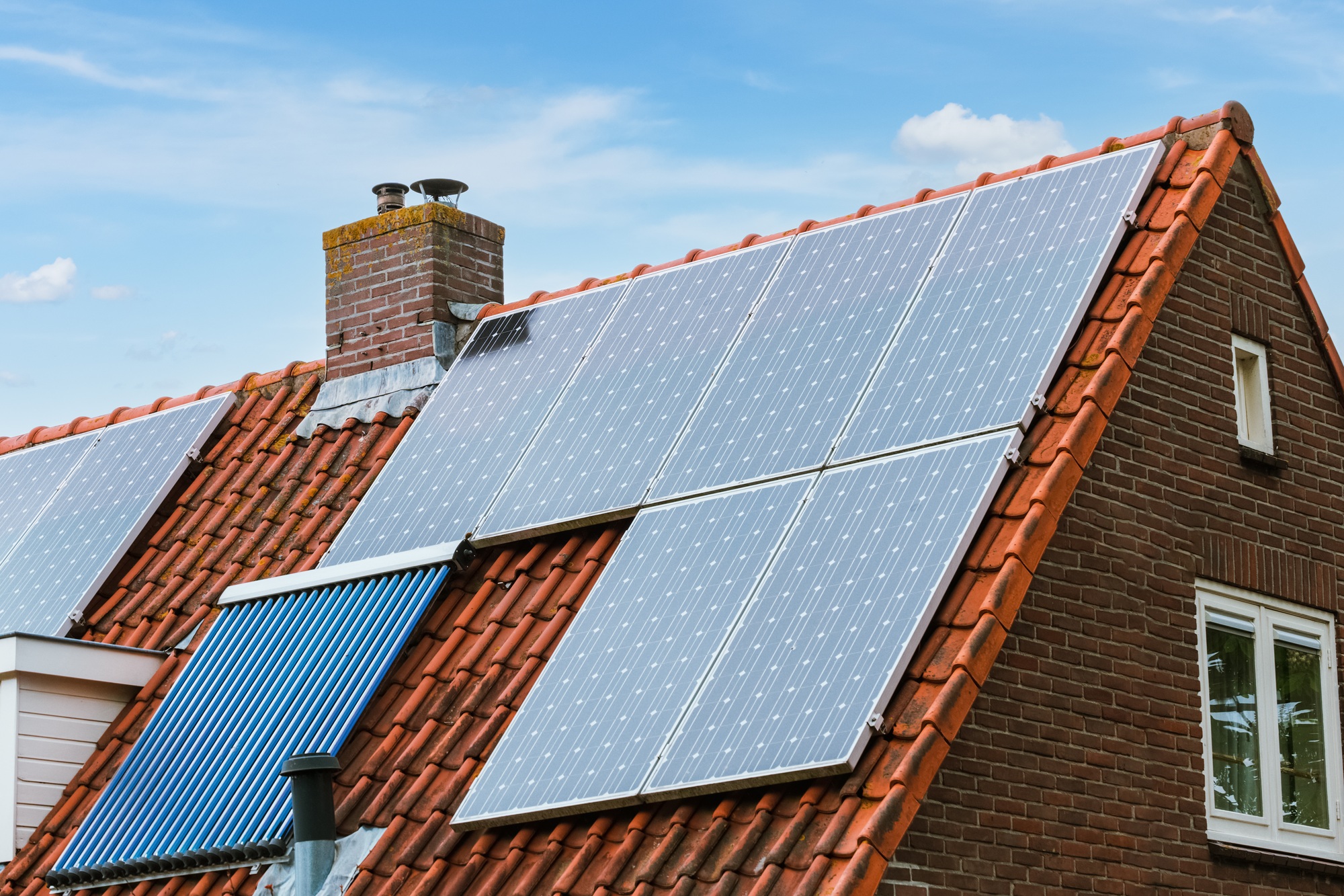 House with solar panels on the roof. Modern ecological energy resource. Green energy by sun.